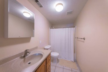 Bej duvarları ve döşemeleri olan geleneksel banyo dışı.