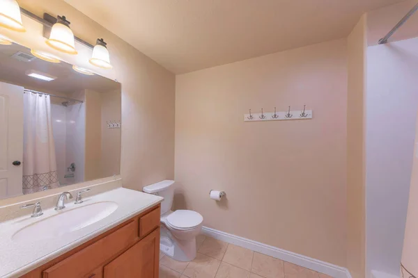 Intérieur de salle de bain traditionnelle avec mur beige et plinthe blanche — Photo