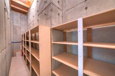 Beton duvarları ve zemini olan bitmemiş dar bir depo.