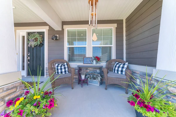 Bonito porche delantero con flores en maceta y dos sillones de brazo tejidos — Foto de Stock