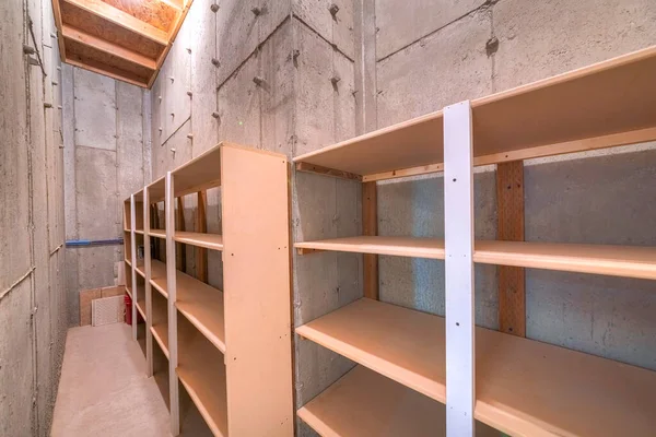 Unfinished narrow storage room with concrete walls and floors — Stock Photo, Image