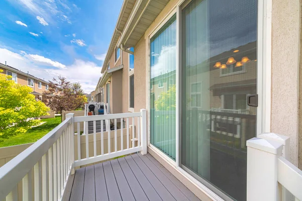 Small deck of a house with sliding glass door and white wood railings — Stock Photo, Image