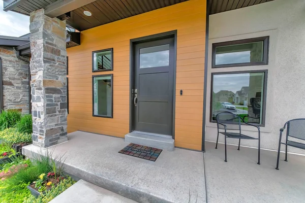 Entrance of a house with black front door and two arm chairs — Stock Photo, Image