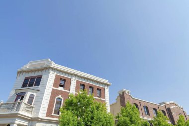 San Marcos, Kaliforniya 'da kırmızı tuğlalı ve beyaz duvar alçılı iki bina.