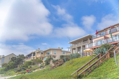 San Diego, Kaliforniya 'da Carlsbad' da çimenli bir yamacın tepesindeki binalar.