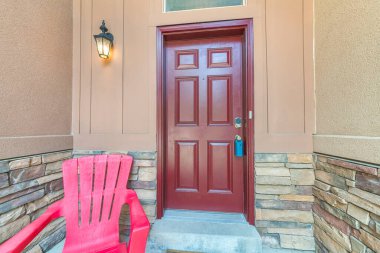 Mavi kilitli kapılı ve solunda lamba olan bordo bir kapı.