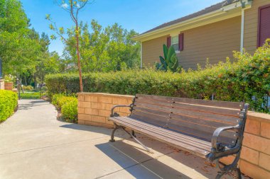 Bahçe tezgahı, çimento duvarın yanında, arkada çalılar var. Ladera Ranch, California 'da.