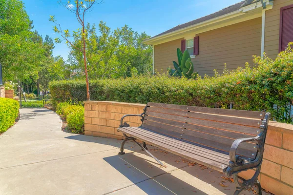 Garden bench near the concrete wall with shrubs at the back in Ladera Ranch, California