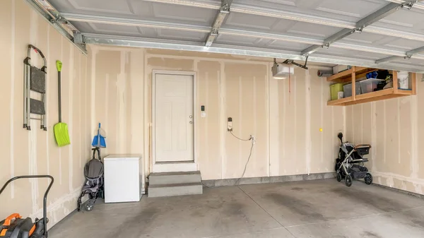Panorama Wnętrze garażu ze śladami napełnienia ścian i białymi drzwiami przeciwpożarowymi — Zdjęcie stockowe