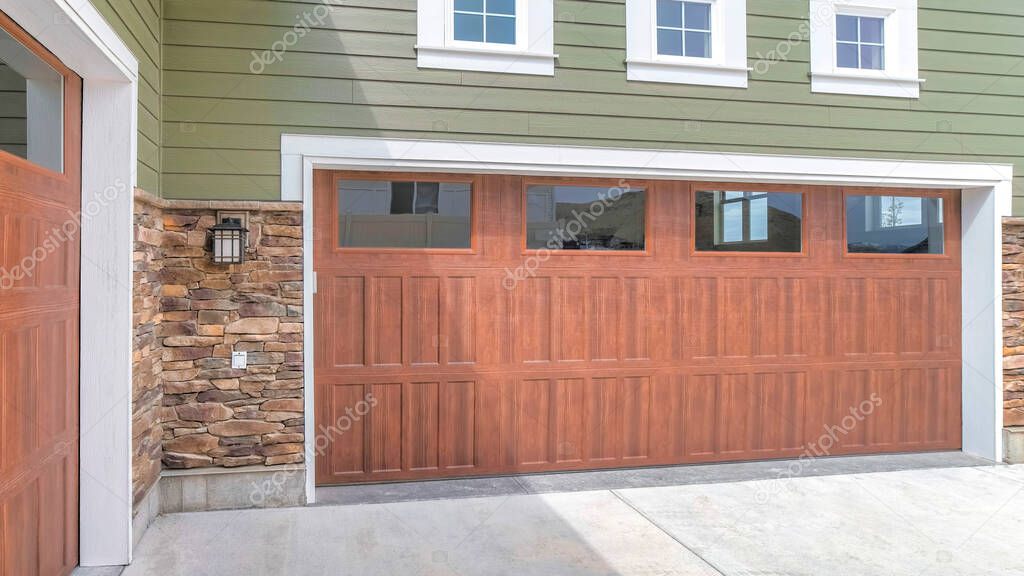Panorama Wooden garage doors with window panels and wall lamp