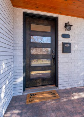 Beyaz tuğlaları ve taş tuğlaları olan bir evin dikey girişi