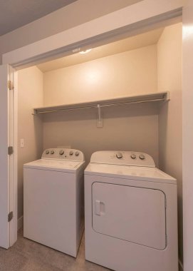 Çamaşır odasında dikey uzanma. İç tarafta beyaz çift katlı kapılar var.