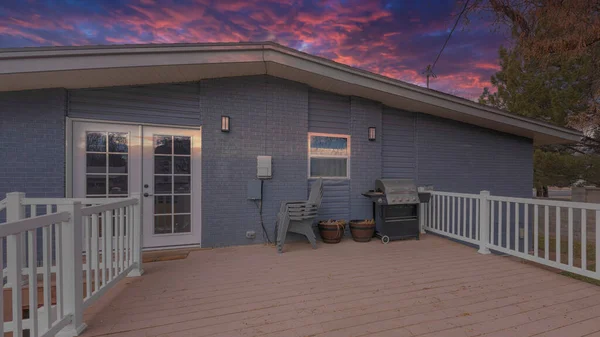 Panorama Dramatischer Sonnenuntergang mit Wolken Deck eines grauen Hauses mit Holzdielen und weißem Geländer — Stockfoto