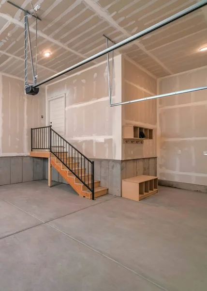 Вертикальний Інтер'єр незакінченого гаража зі сходами, що ведуть до дверей — стокове фото