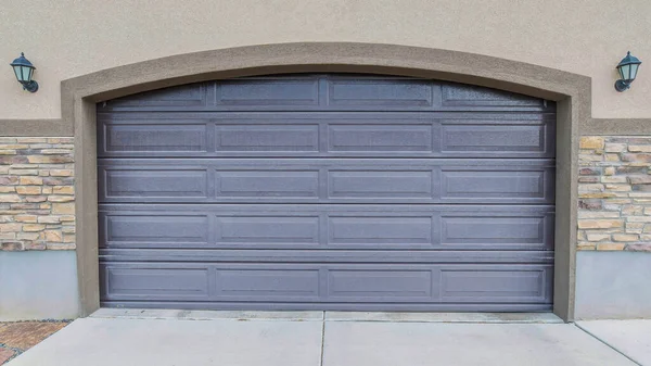 Panorama Exterior de una puerta de garaje gris arqueado con dos lámparas de pared en el lateral — Foto de Stock