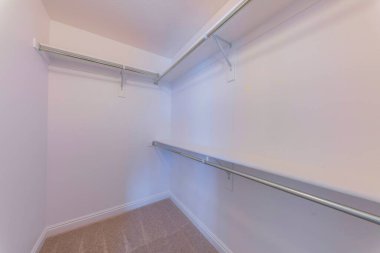 Duvara monte edilmiş rafları, parantezleri ve metal çubukları olan gömme dolap.