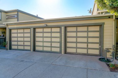 San Francisco, California 'da yeşil bukleli üç tente kapısı. Vinil kaplamalı ve beton kaplamalı garaj kapısı..