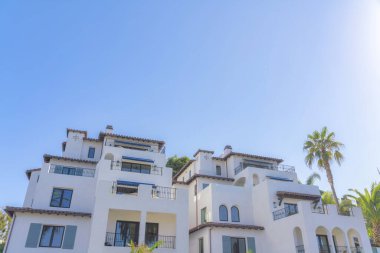 San Clemente, Kaliforniya 'da, Akdeniz tarzı dış görünüşlü, tıpatıp aynı iki bina. Balkonları, yansıtıcı pencereleri ve açık gökyüzüne karşı kayan kapıları olan evler..