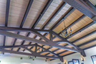 San Clemente, Kaliforniya 'da mum avizeli tavan. İçerisi koyu kahverengi ahşap tavan kirişleri ve pencerelere yakın beyaz duvarları olan bir tavan..