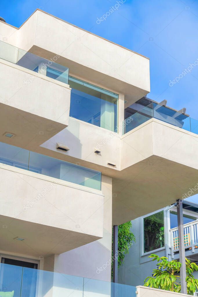 Modern apartment building in a low angle view at San Clemente, California. Beige apartment building exteriorwith glass railings on balconies.