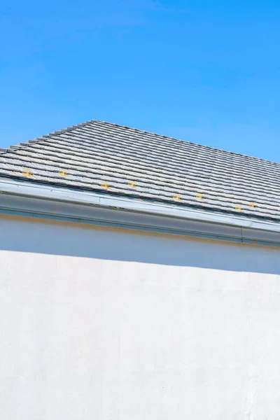 加利福尼亚州圣何塞市一座低视角房屋的灰色屋顶在翘起 房子的外面 白色的墙壁 灰色的屋顶 衬托着明亮的蓝天背景 — 图库照片