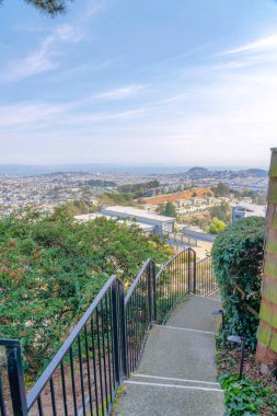 San Francisco, California 'da bir apartmanın merdivenlerinden tüm bir topluluğu görmek. Beton merdivenlerin yüksek açılı görüntüsü ve yan taraftaki ağaçların yanındaki metal tırabzanlar..