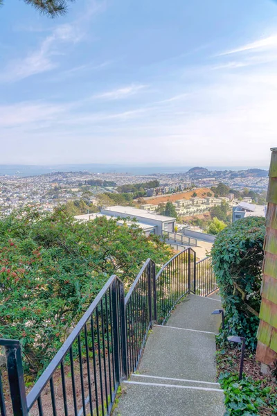 San Francisco, California 'da bir apartmanın merdivenlerinden tüm bir topluluğu görmek. Beton merdivenlerin yüksek açılı görüntüsü ve yan taraftaki ağaçların yanındaki metal tırabzanlar..