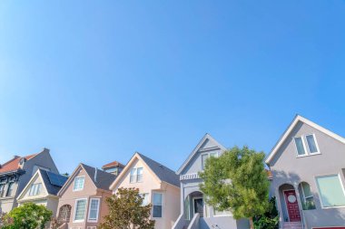 San Francisco, California 'da alçak açılı küçük evler. Arka arkaya çatılı ve merdivenleri ön kapıya çıkan evlerin dışında..