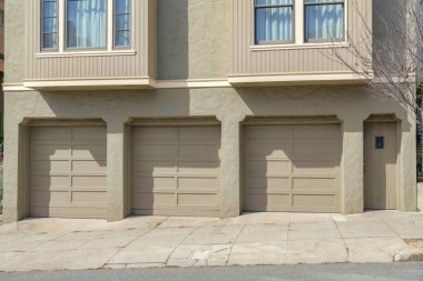 San Francisco, Kaliforniya 'da açık gri dış görünüşlü bir evin üç garaj kapısı. Ön kapı girişinin yanında iki giriş penceresinin altında üç kubbeli garaj kapısı var..