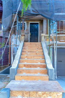 İnşaat alanının dışında San Francisco, California 'da güvenlik ağı var. Bitmemiş bir kasaba evinin girişi. Önünde siyah kapıya çıkan merdivenler var..