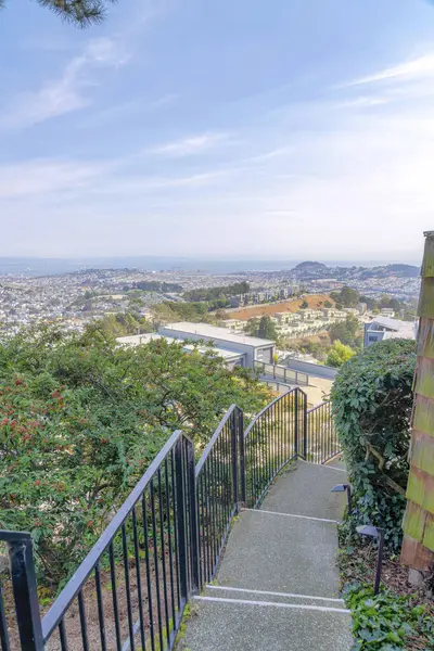 San Francisco, California 'da bir apartmanın merdivenlerinden tüm bir topluluğu görmek. Beton merdivenlerin yüksek açılı görüntüsü ve yan taraftaki ağaçların yanındaki metal tırabzanlar..