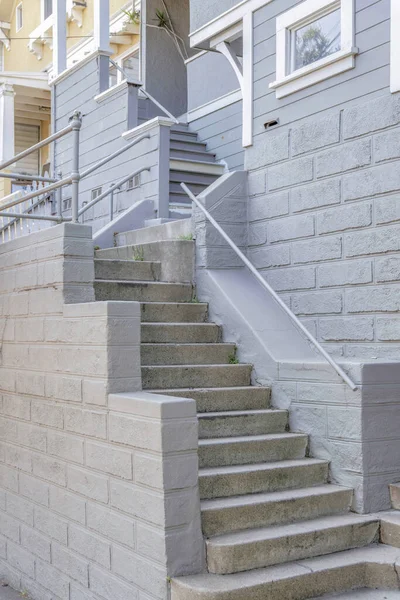 コンクリートブロック壁と屋外の階段は カリフォルニア州サンフランシスコの家に向かっています 灰色の外観の家の玄関ドアへの階段を持つ家の入り口の外観 — ストック写真