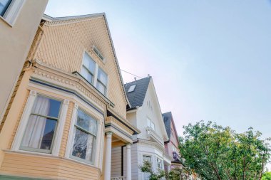 San Francisco, California 'nın banliyölerindeki evlerin düşük açılı görüntüsü. Parlak gökyüzüne karşı ahşap kaplamalı dış mahalle..