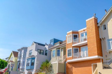 San Francisco, California 'nın banliyölerindeki kompleks evler. Zona ve vinil kaplamalı mahalle evleri ön kapıda balkon ve merdiven manzaralı..