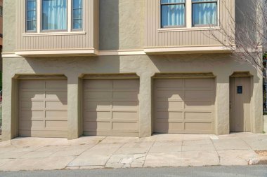 San Francisco, Kaliforniya 'da açık gri dış görünüşlü bir evin üç garaj kapısı. Ön kapı girişinin yanında iki giriş penceresinin altında üç kubbeli garaj kapısı var..