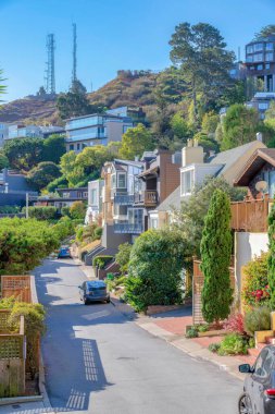 San Francisco, California 'da bir yamaçtaki yerleşim bölgesinde beton yokuş yukarı. Yamaçta gökyüzüne karşı kuleleri olan farklı yerleşim yerleri var..