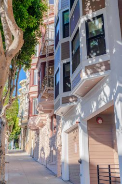 San Francisco, California 'da farklı tasarım yapıları olan kompleks apartmanlar. Garajlı, eğimli beton kaldırımlı ve garaj yolu olan evler..