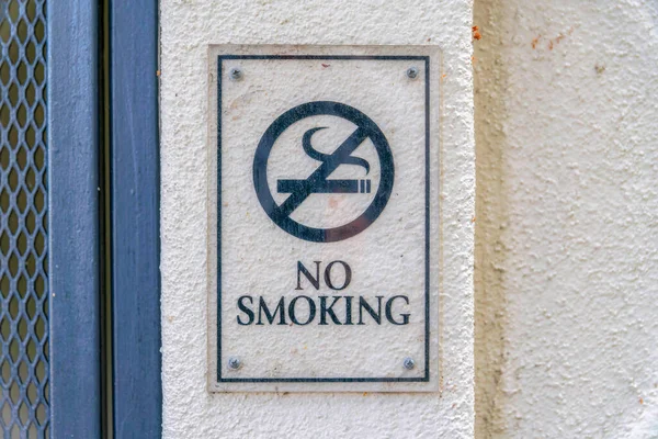 加利福尼亚州圣何塞市硅谷的米色墙壁上 闪烁着禁止吸烟的标语 在左边深灰色金属网墙附近贴有禁烟标志的特写 — 图库照片