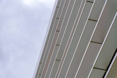 Silikon Vadisi, San Jose Körfezi, Kaliforniya 'da alçak açılı bir binanın pencere güneşliği. Bulutlu gökyüzü arkaplanına karşı beton bir tente görüntüsü.
