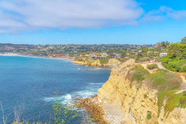 Güney Kaliforniya, San Diego 'daki La Jolla kıyı bölgesi. Sağdaki Pasifik Okyanusu kıyısındaki dağın kenarındaki binaların manzarası sağda..