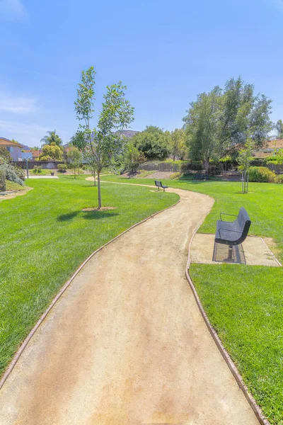 加利福尼亚州圣地亚哥的一条泥泞平坦的小路 旁边有长椅和树木 在一个公园的小径上 篮球场在住宅区 背对着天空 — 图库照片