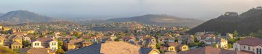 San Marcos, California 'daki dağlık bir banliyö toplumunun panoramik manzarası. Çifte Tepe Parkı 'ndaki ağaçlı büyük evlerin çatıları görünüyor..
