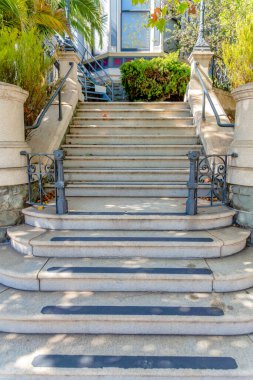 Her basamakta kayma önleyici şeritler metal çitler ve tırabzanlar olan perron merdivenleri. San Francisco, Kaliforniya 'da bir apartmana çıkan açık merdiven..