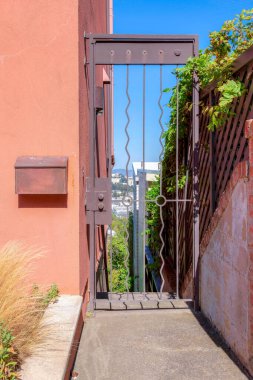 San Francisco, California 'da duvarında posta kutusu olan tek bir metal kapı. Girişte solda çimenler ve sağda ahşap çitler var..