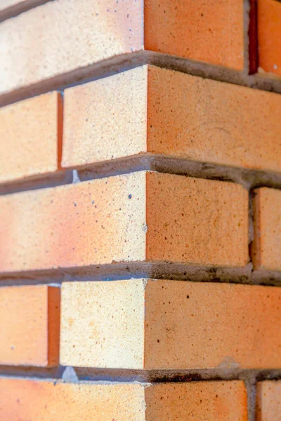 Corner wall with bricks running bond pattern in San Francisco, California. Close-up of a wall with orange bricks with straight lines pattern.