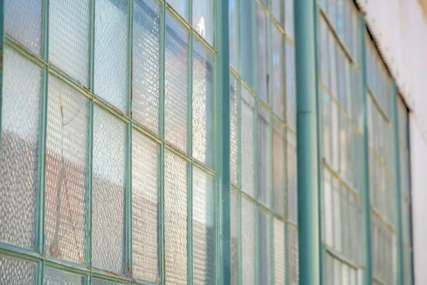 Close-up of a window pane in San Francisco, California. Selective focus of frosted glass panes of a window with blue green grids in a side view.