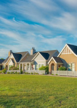 Dikey Whispy beyaz bulutları, Daybreak, Güney Ürdün, Utah 'ta önü çimenli ve patikalı evleri tespit etti. Geleneksel ve Fransız ülkesine sahip evlerin dışı açık mavi gökyüzüne karşı dizayn edilmiş..