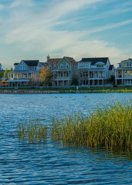 Utah, Daybreak 'te günbatımında Oquirrh Gölü kıyısı boyunca dikey Whispy beyaz bulutları. Sol tarafta kapalı bir rıhtım ve arka planda gökyüzü ufkuna ve dağa karşı büyük evler var..