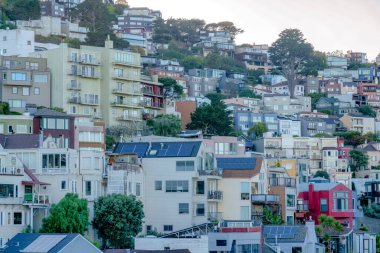 Apartment buildings on a mountain at San Francisco, California. Residential area with multi-storey buildings against the white sky background.