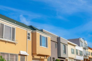 Complex houses exterior with different structures in San Francisco, California. There are houses with picture windows and a view of a house with emergency stairs on the right.